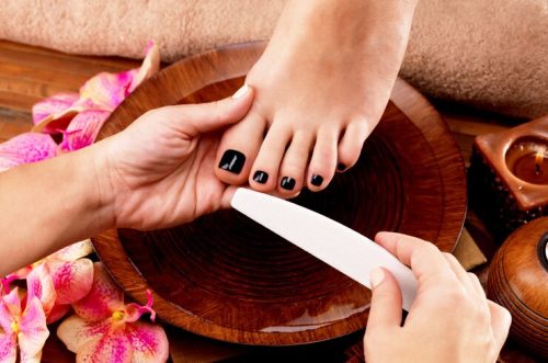 pedicurist-master-makes-pedicure-woman-s-legs-spa-treatment-concept_186202-7773